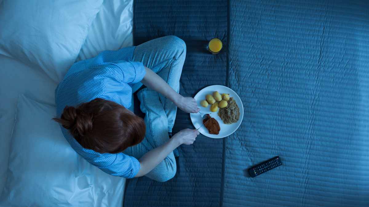 Woman who eats at night on her bed